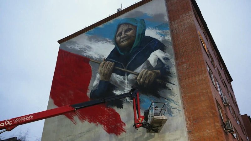 Стрит-арт бабушки со знаменем Победы появился на стене дома в Руетове